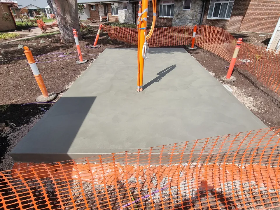 Finished concrete pad with electrical conduits cast through it, poured by A and J Contractors