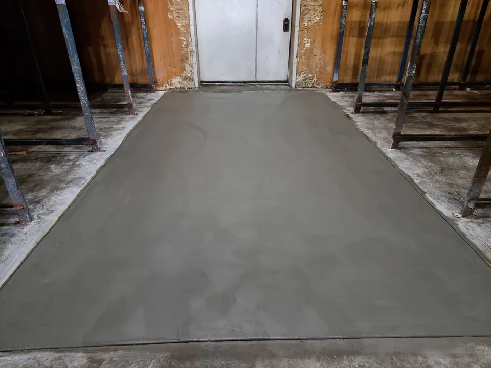 Replaced section of concrete floor finished flush between steel racking frames
