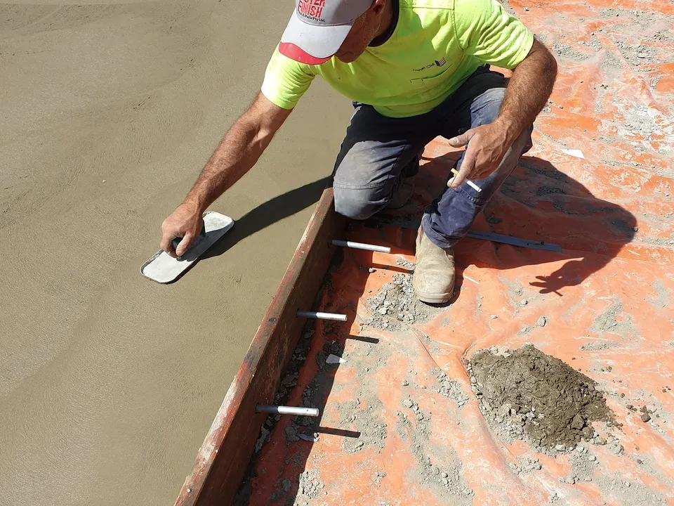 A and J Contractors concreter hand-finishing the edge of a freshly poured slab