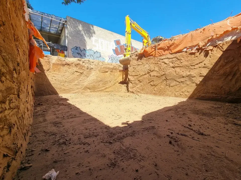 Deep bulk excavation with vertical cut walls beside a commercial building in Adelaide