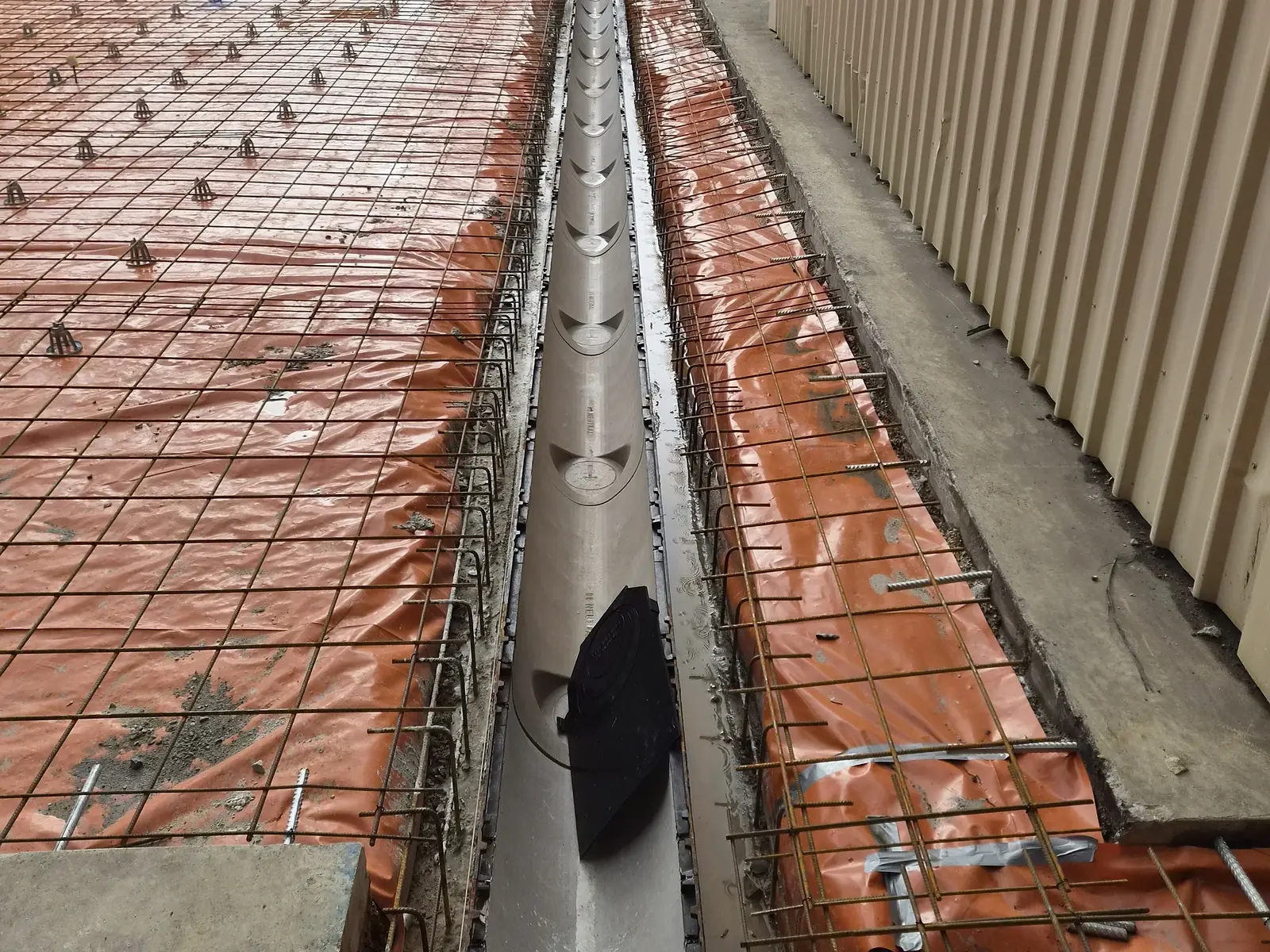 Trench drain installed in reinforcement mesh beside a warehouse in Greenfields, ready for the concrete pour
