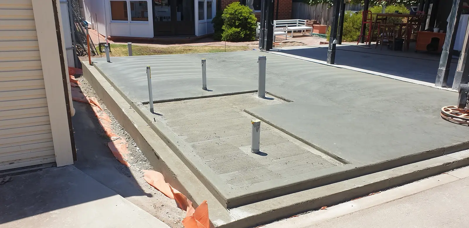 Finished raft slab for a house extension, with plumbing penetrations set through the slab