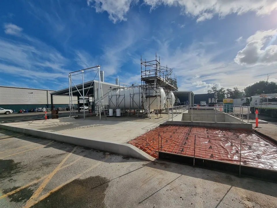 Concrete bund walls under construction around industrial storage tanks in Adelaide